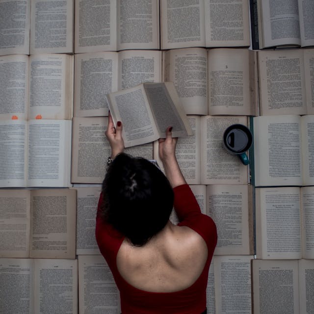 Photo by Abner Navarro: https://www.pexels.com/photo/woman-lying-on-open-books-and-reading-19446756/