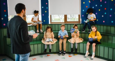 Photo by Anastasia Shuraeva: https://www.pexels.com/photo/man-reading-in-front-of-children-8466901/